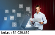 Young man using a multifunction printer to scan documents in an office environment with digital icons around. Стоковое фото, фотограф Сергей Толмачёв / Фотобанк Лори