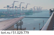 Tokyo, Japan - Oct 13 2024, 4k panoramic view of docks with cranes and containers, in foreground is signage with word Tokyo on roof of Tokyo cruise port, view from deck of MSC Bellissima, Tokyo, Japan. Редакционное видео, видеограф Сергей Богомяко / Фотобанк Лори