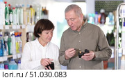 Couple elderly man and woman buyers testing perfume in household chemicals store. Стоковое видео, видеограф Яков Филимонов / Фотобанк Лори
