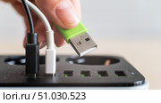 Modern convenient multi-port usb charger for devices. Close-up of a female hand plugging multi-colored cables into a power outlet. Macro. Стоковое фото, фотограф Михаил Решетников / Фотобанк Лори