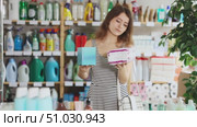 Girl view trademark sign on label, chooses eco friendly panty liners of specific manufacturer. Customer examines product, reads composition on label. Стоковое видео, видеограф Яков Филимонов / Фотобанк Лори