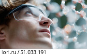 Young scientist examining molecular structure with curiosity in a laboratory setting. Стоковое AI-изображение, AI-художник Сергей Толмачёв / Фотобанк Лори