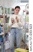 Girl housewife in household store examines package, chooses tin can. Стоковое видео, видеограф Яков Филимонов / Фотобанк Лори