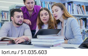 Group portrait of smiling positive engaged in research, working together in public library. Стоковое видео, видеограф Яков Филимонов / Фотобанк Лори