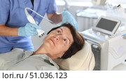Elderly woman getting facial deep hydration procedure from experienced cosmetologist in aesthetic medicine office. Стоковое видео, видеограф Яков Филимонов / Фотобанк Лори