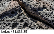 Abstract texture background showing closeup of dark volcanic rock with crack, geology concept with porous lava stone surface for wallpaper or design element. Стоковое AI-изображение, AI-художник Павел Муравьев / Фотобанк Лори