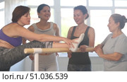 Group of cheerful relaxed women of different ages casually socializing and stretching at ballet barre after dance practice in amateur choreographic studio. Стоковое видео, видеограф Яков Филимонов / Фотобанк Лори