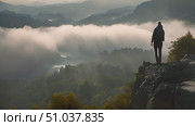 Active person is standing at the summit of a mountain, taking in the expansive view around them. Стоковое AI-видео, аниматор Данила Большаков / Фотобанк Лори