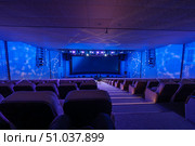Spacious auditorium with blue lighting and theater setup. Стоковое фото, фотограф Антон Гвоздиков / Фотобанк Лори
