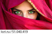 A mysterious figure with striking green eyes peers from behind a vibrant red veil, evoking themes of hidden identity, cultural tradition, and untold stories. Стоковое AI-изображение, AI-художник Ольга Сухарева / Фотобанк Лори