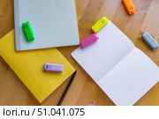 Neatly laid out notebooks or notebooks in delicate pastel colors on a wooden table, next to multi-colored highlighter markers in the shape of cute animals, blue, yellow, pink and orange and a black gel pen and an open blank notebook, ready to write. The personnel convey the mood of the new school year, creativity, planning and organization. Редакционное фото, фотограф Анастасия Мерчик / Фотобанк Лори