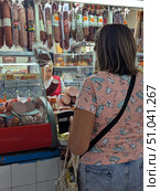 Женщина покупает мясную продукцию на рынке. Редакционное фото, фотограф Юлия Юриева / Фотобанк Лори