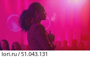 A woman stands confidently in front of a vibrant pink light, casting a striking silhouette against the colorful backdrop. Стоковое AI-видео, аниматор Данила Большаков / Фотобанк Лори