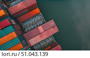 Aerial view of container ship navigating the vast expanse of the ocean, carrying cargo across the water. Стоковое AI-видео, аниматор Данила Большаков / Фотобанк Лори