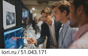 Young professionals engage in data analysis during a technology conference in a bustling exhibit hall. Стоковое AI-видео, аниматор Сергей Толмачёв / Фотобанк Лори