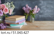 Colorful flowers and stacked books create a calm study space in a cozy room. Стоковое AI-видео, аниматор Сергей Толмачёв / Фотобанк Лори