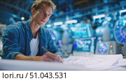 Young man focused on technical drawings in a bright, modern workspace during the day. Стоковое AI-видео, аниматор Сергей Толмачёв / Фотобанк Лори