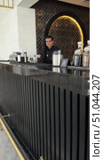 Professional bartender in black apron pours drink from shaker into glass.Male bartender pouring alcohol in glass, A young bartender making luxury cocktail. Редакционное видео, видеограф Zita Khasanova / Фотобанк Лори