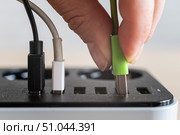 Modern convenient multi-port usb charger for devices. Close-up of a female hand plugging multi-colored cables into a power outlet. Macro. Стоковое фото, фотограф Михаил Решетников / Фотобанк Лори