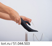 A woman makes a purchase and puts a dildo in a bag on a white background. Close-up of female hands with a black vibrator. Стоковое фото, фотограф Михаил Решетников / Фотобанк Лори