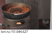 Chef adding raisins to carrots cooking in a cauldron on a stove. Стоковое видео, видеограф Константин Шишкин / Фотобанк Лори