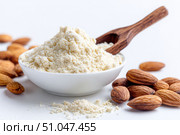 Almond flour. Almond nuts and almond flour in a wooden bowl and spoon. White table background. Grated almonds pile. Gluten-free produce for health. Low Carb Keto, celiac, paleo, and wheat-free diets. Стоковое AI-изображение, AI-художник Марина Демидюк / Фотобанк Лори