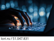 Person typing at laptop computer at night. Female uses keyboard, shakes buttons with fingers. Internet security, cyber attack. Trendy neon light. Creative dark color of orange, black, and teal blue. Стоковое AI-изображение, AI-художник Марина Демидюк / Фотобанк Лори