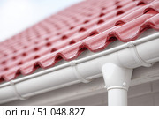Contemporary Gutter Installed on a Residential House Roof to Enhance Functionality. Clean well maintained rain gutter system. Roof architecture effectively. Polymer storm drainage. Home architectural. Стоковое AI-изображение, AI-художник Марина Демидюк / Фотобанк Лори