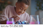 Young inventor explores robotics and science with colorful liquids during an educational activity at home. Стоковое AI-видео, аниматор Сергей Толмачёв / Фотобанк Лори