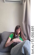 Beautiful young woman with long hair in a green T-shirt strokes a running cat while sitting on a sofa. Not a gentle cat. Стоковое видео, видеограф Кашапова Эльвира / Фотобанк Лори