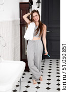 Beautiful young woman in gray pajamas, braces with white towel on shoulder in bathroom smiling and looking at camera. Стоковое фото, фотограф Кашапова Эльвира / Фотобанк Лори