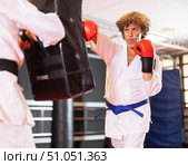 Blue‑belt karateka punching shield in dojo training. Стоковое фото, фотограф Яков Филимонов / Фотобанк Лори