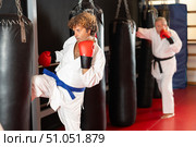 Man in karate uniform training with punching bag in gym. Стоковое фото, фотограф Яков Филимонов / Фотобанк Лори