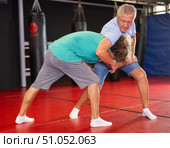 Elderly man learning self-defense grips and escapes at gym. Стоковое фото, фотограф Яков Филимонов / Фотобанк Лори