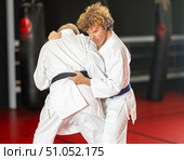 Middle‑aged aikido practitioner training with partner in dojo. Стоковое фото, фотограф Яков Филимонов / Фотобанк Лори
