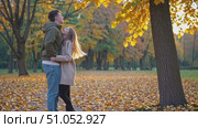 A Romantic Autumn Moment: A Couple Joyfully Embraces Amidst a Colorful Canopy of Falling Leaves and Warm Fall Colors in a Serene Park Setting. Стоковое AI-видео, аниматор Владимир Федоров / Фотобанк Лори