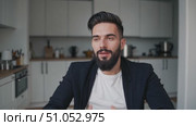 Engaging Conversation: A Charismatic Young Man in a Modern Kitchen Shows Enthusiasm and Warmth Through Expressive Gestures and a Friendly Smile. Стоковое AI-видео, аниматор Владимир Федоров / Фотобанк Лори