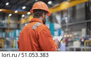 Industrial worker conducts safety inspection in manufacturing facility during daytime hours. Стоковое AI-видео, аниматор Сергей Толмачёв / Фотобанк Лори