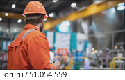 Worker in safety gear takes notes during a site inspection in an industrial facility. Стоковое AI-видео, аниматор Сергей Толмачёв / Фотобанк Лори
