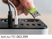 Modern convenient multi-port usb charger for devices. Close-up of a female hand plugging multi-colored cables into a power outlet. Macro. Стоковое фото, фотограф Михаил Решетников / Фотобанк Лори