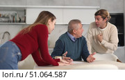 Elderly man during family quarrel with man and woman couple in kitchen. Стоковое видео, видеограф Яков Филимонов / Фотобанк Лори