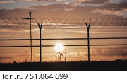 Airport service truck passing behind barbed wire fence at sunset. Стоковое видео, видеограф Mikhail Davidovich / Фотобанк Лори
