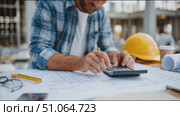Construction planner working on blueprints at a job site while using a calculator and pencil. Стоковое AI-видео, аниматор Сергей Толмачёв / Фотобанк Лори