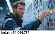 Control operator adjusts machinery settings in industrial facility during evening shift. Стоковое AI-видео, аниматор Сергей Толмачёв / Фотобанк Лори