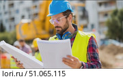 Construction worker reviews plans on site while overseeing project progress during daylight hours. Стоковое AI-видео, аниматор Сергей Толмачёв / Фотобанк Лори