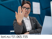 Business woman saying hello in Vulcan style while sitting at her desk in the office. Стоковое фото, фотограф Михаил Решетников / Фотобанк Лори