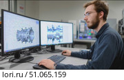 Engineer analyzes turbine model using advanced software in a tech lab during day hours. Стоковое AI-видео, аниматор Сергей Толмачёв / Фотобанк Лори