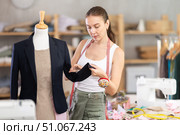 Young tailoress trying ready jacket on mannequin. Стоковое фото, фотограф Яков Филимонов / Фотобанк Лори