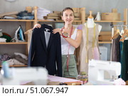 Young tailoress handing over finished blazer to female client. Стоковое фото, фотограф Яков Филимонов / Фотобанк Лори