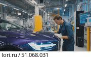 Worker performs quality inspection on a luxury vehicle in a modern factory setting. Стоковое AI-видео, аниматор Сергей Толмачёв / Фотобанк Лори